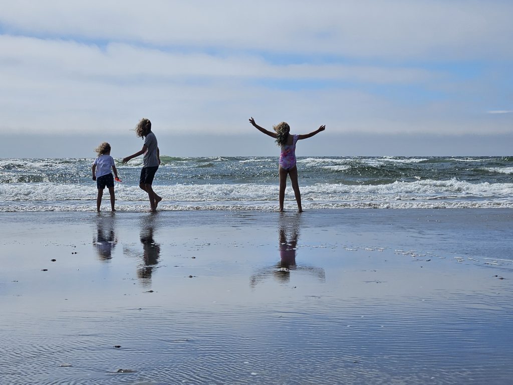 Three children running on the beach